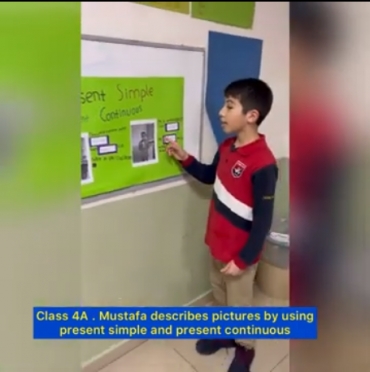Students of class 4A presented their posters that have been made by them about simple present and present continuous.