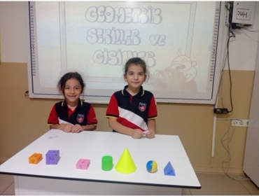 2/A sınıfı öğrencileri Matematik dersinde geometrik cisimler ve günlük hayatta geometrik cisimlerin nerelerde karşımıza çıktığını somut materyaller kullanarak eğlenceli bir oyunla öğrendiler.